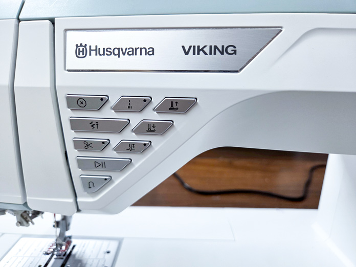 Push buttons on a white sewing machine