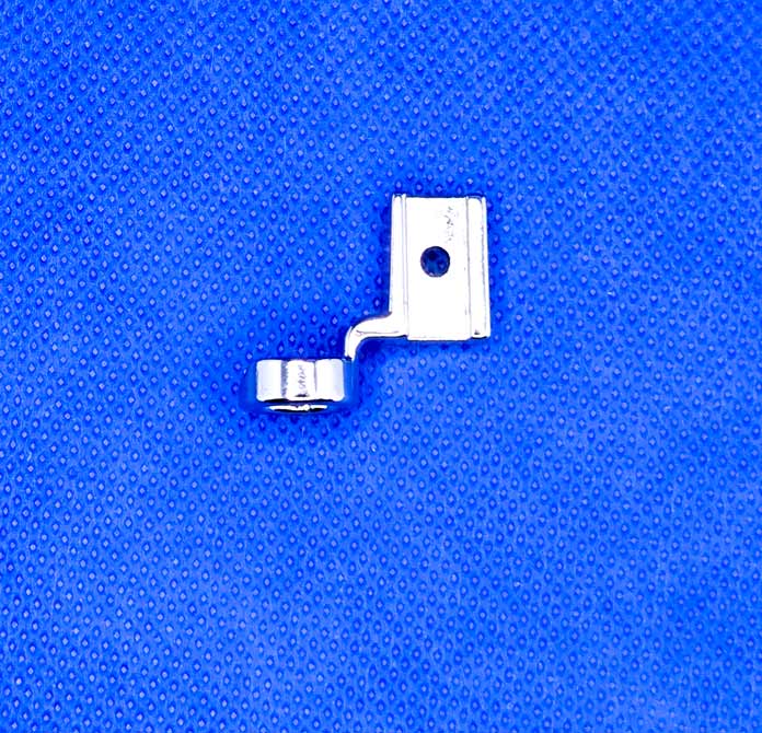 A metal presser foot on a blue background