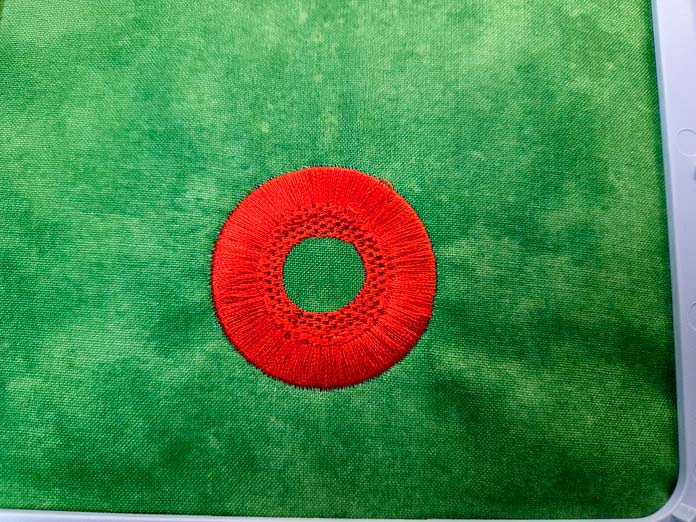 Orange stitching on green fabric