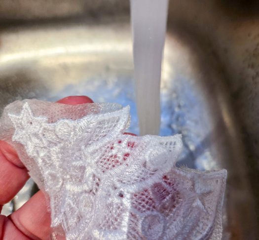 A lace ornament under a stream of water; Gütermann cotton thread