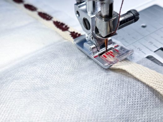 Twill tape under a sewing machine presser foot