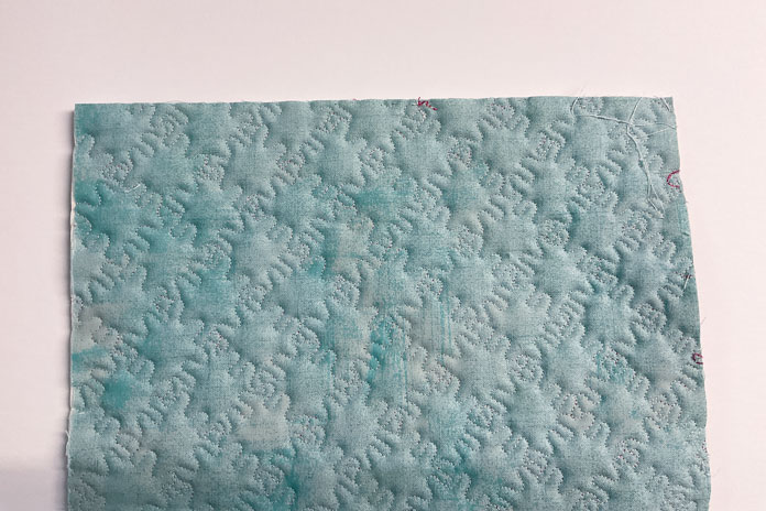 Stitch quality shown on the back of a green piece of fabric