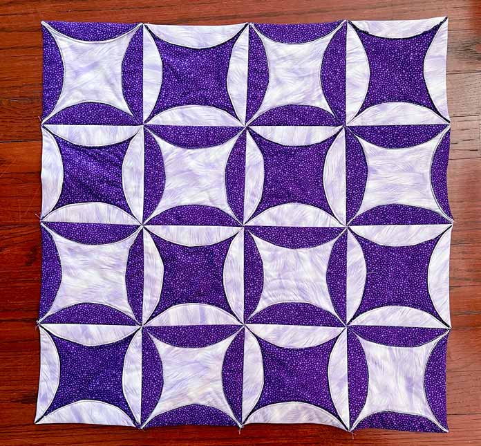 The Completed Cathedral Window quilt in dark purple and mauve fabrics