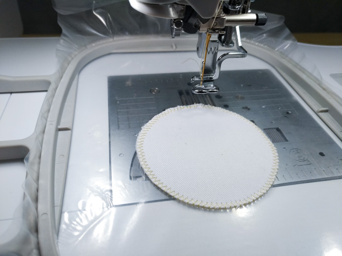 A circular piece of white fabric with stitching around it on the Brother Luminaire. Brother Luminaire XP, Brother ScanNCut