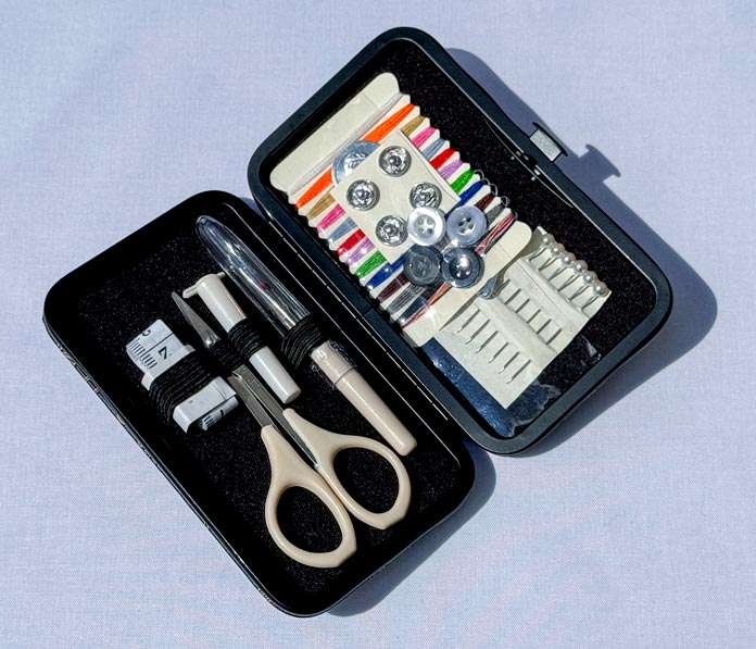 A Hemline Gold Sewing Kit containing scissors, buttons, threads, needles, a tape measure, and a seam ripper. Hemline Gold Multi-Use Craft Bag (28.5cm x 36.5cm x 17.8cm), Hemline Gold Sewing Kit, Hemline Gold Quilters 4-in-1 Multi-Mat (30cm x 24cm), Hemline Gold Quilters Clips (Pack of 30), Hemline Gold Retractable Tape Measure - 150cm/60, oliso M3Pro Project Iron – Coral, OLFA 45mm RTY-2/DX/MAG Ergonomic Rotary Cutter – Magenta, OLFA RM-MG - 24″ x 36″ Double Sided Rotary Mat, UNIQUE Sewing Tools Holder, OLFA QR-6x12 - 6″ x 12″ Frosted Acrylic Ruler, OLFA QR-6x24 - 6″ x 24″ Frosted Acrylic Ruler, Fairfield Quilter's 80/20 Quilt Batting - 229 x 274cm (90″ x 108″).