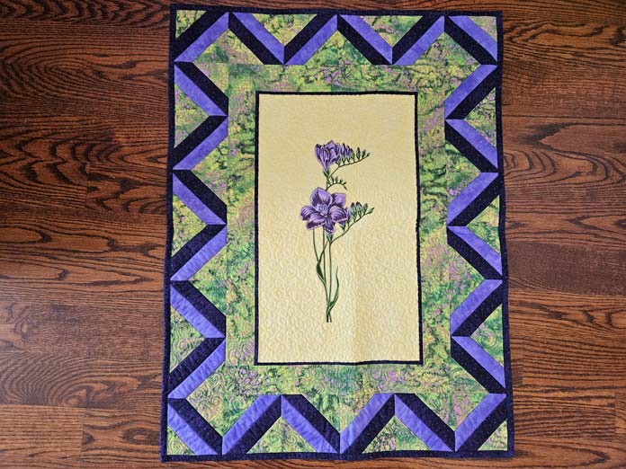 A purple, yellow, and green wall hanging; quilting, embroidery machine, machine embroidery, quilting techniques, Husqvarna VIKING, quilt labels, embroidery software, quilt embellishments, quilting tools, QUILTsocial