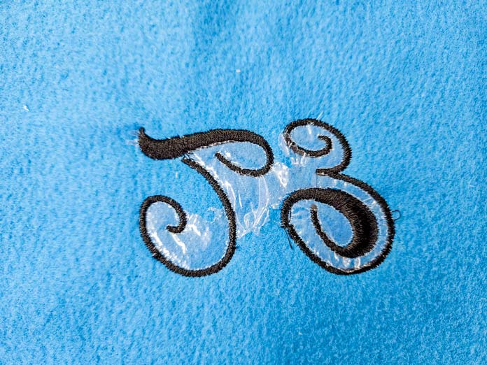 Black lettering on blue fabric; Sulky Heat-Away Clear Film stabilizer 