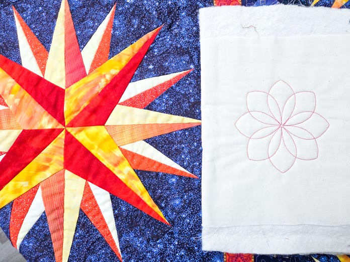 An orange and yellow fabric compass on blue fabric, and an 8-petal motif in red stitching on beige fabric