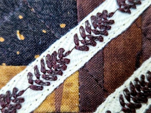 Decorative machine stitches in brown on twill tape