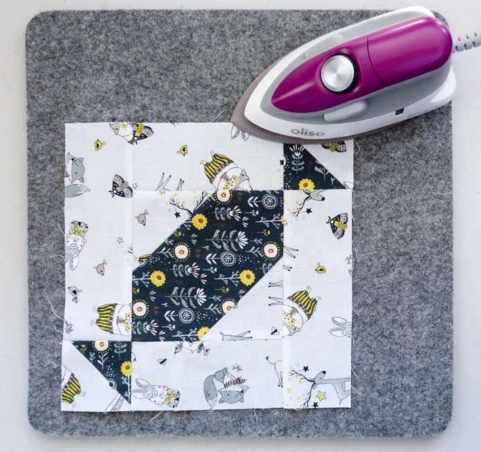 The 2½″ x 7½″ rectangle/Half Square Triangle units are sewn to the opposite sides of the center block. Whimsicals collection by Michael Miller Fabrics, UNIQUE Folding Cutting Mat, Sew Easy Quilting Ruler, Oliso Pro TG1600 Smart Iron, Oliso M2Pro Mini Project Iron, UNIQUE quilting Wool Pressing Mat