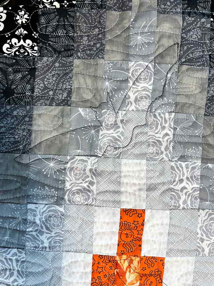 Quilted bats showing subtly on the front of the table runner with black thread