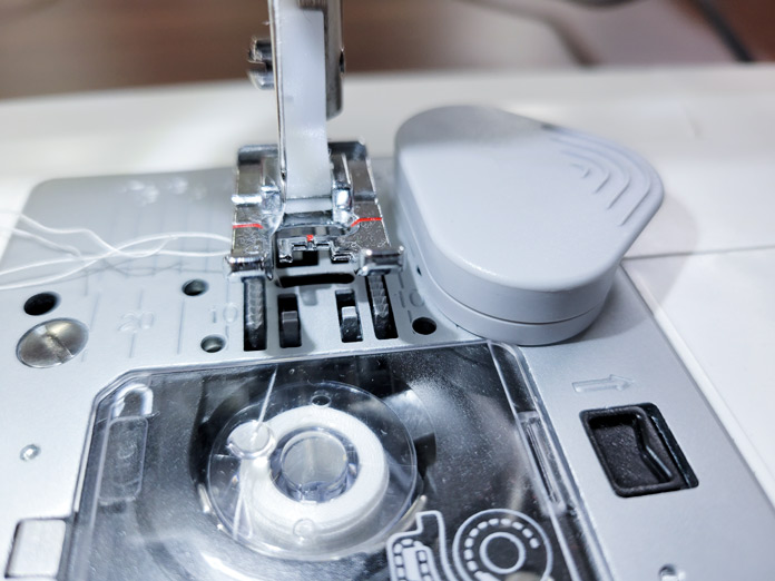 A gray magnet on the stitch plate of the Husqvarna VIKING ONYX 25 sewing machine
