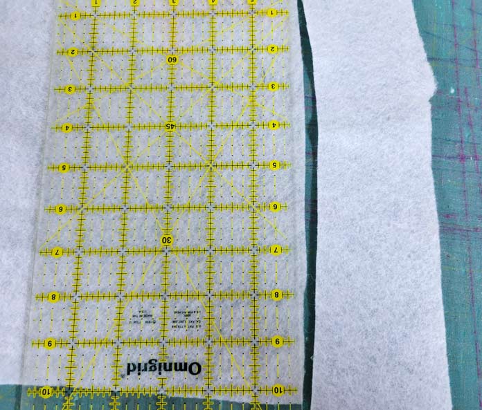 Two white pieces of fabric with an Omnigrid quilting grid ruler; Husqvarna VIKING ONXY 25