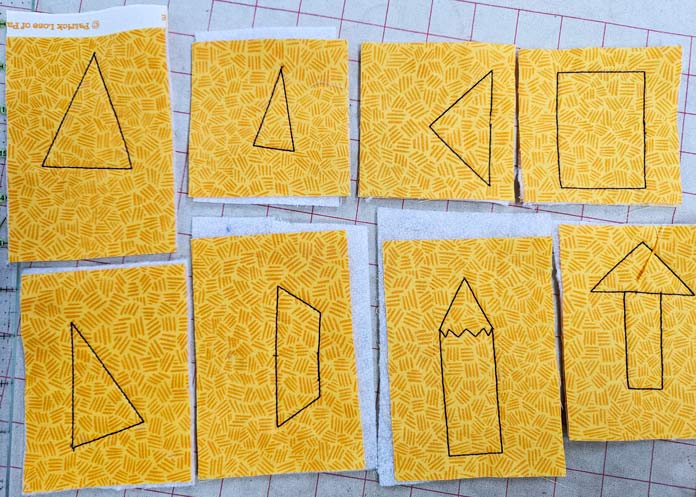 Outlines of various shapes on yellow fabric