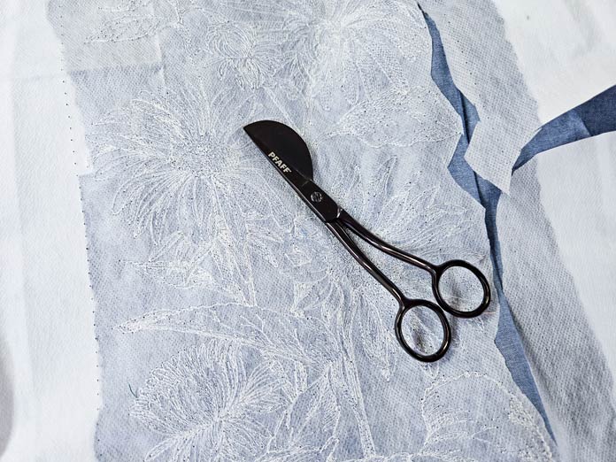 A pair of applique scissors on white fabric
