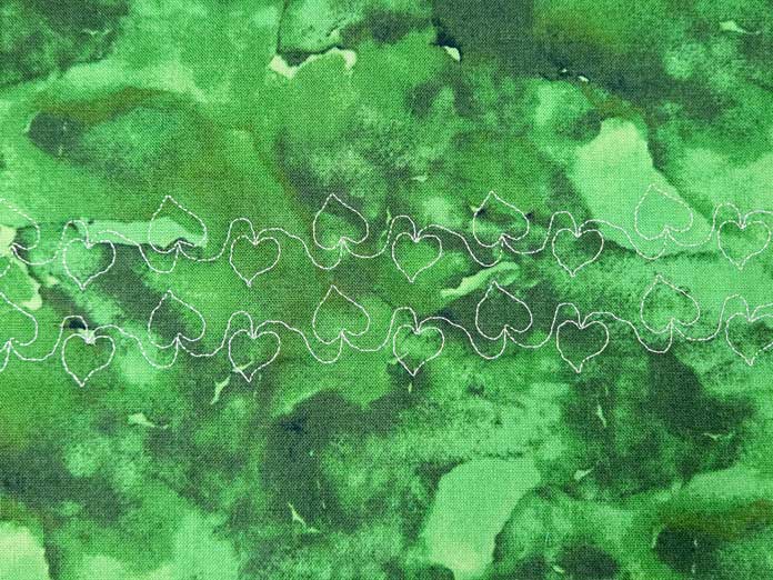 White stitches on green fabric