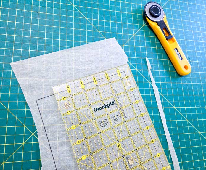 Tissue paper, a quilter’s ruler, and a rotary cutter
