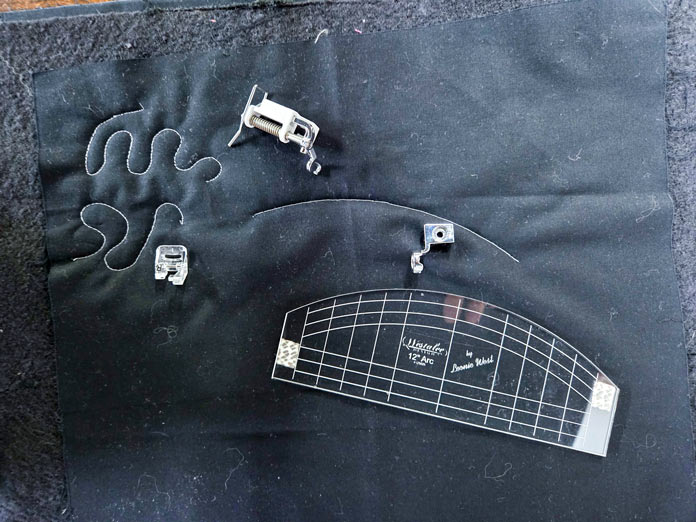 Free-motion presser feet and a clear ruler on black fabric