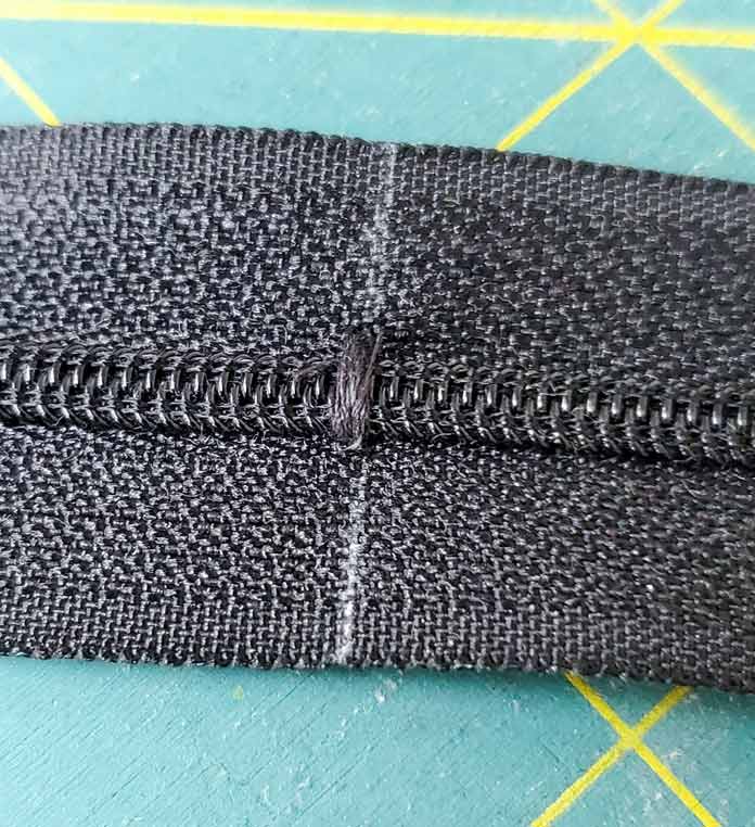 A black zipper with a thread zipper stop. Husqvarna Viking Designer Sapphire 85, Inspira EZ Snip Curved Scissors