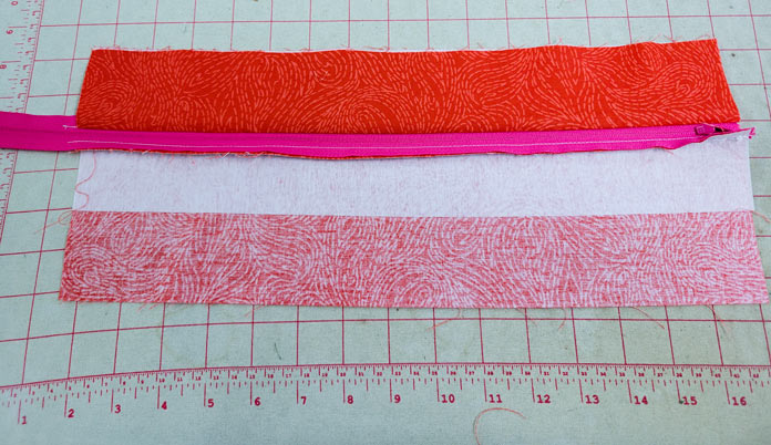 A pink zipper with orange fabric and white fabric; making a project bag on the Husqvarna VIKING ONYX 25