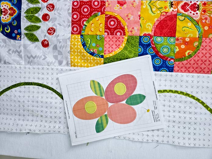 A printout of a floral design on white fabric with colorful squares
