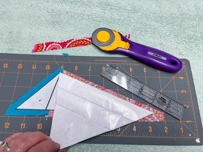 Fabric 2 trimmed with ¼" seam allowance and whole unit on cutting mat with ruler and rotary cutter