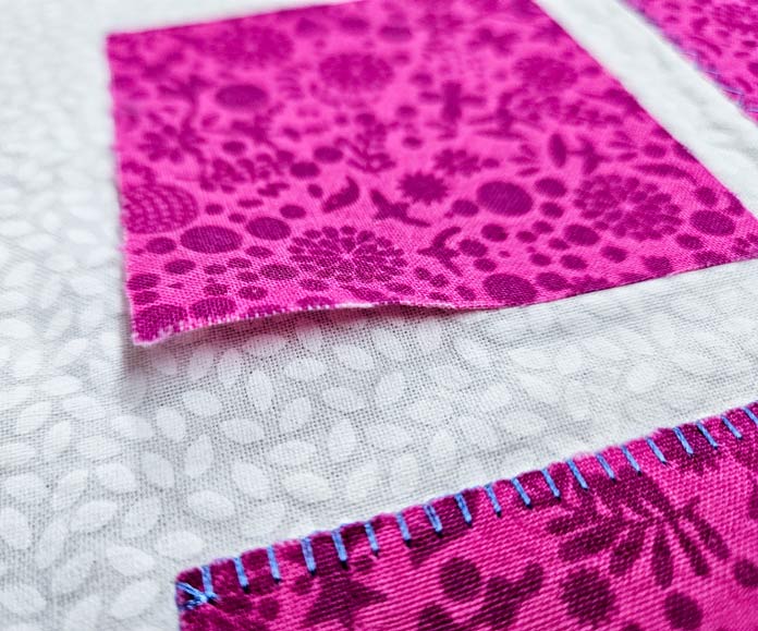 A pink square on white fabric; HeatnBond, fusible web, sewing, applique, quilting, hemming, fabric adhesive, SoftStretch, Lite, Featherlite, Ultra, sewing tips, crafting, fabric experiments