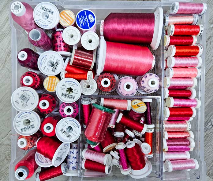 A selection of red and pink embroidery threads; machine embroidery, embroidery tools, embroidery supplies, quilting, Husqvarna VIKING, embroidery hoops, stabilizers, sewing machine, embroidery techniques, QUILTsocial, Designer Epic 3