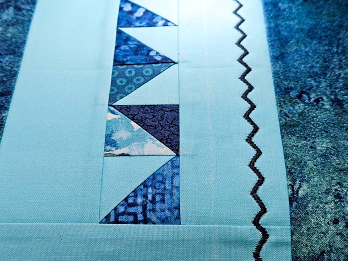 Black stitching on blue fabric