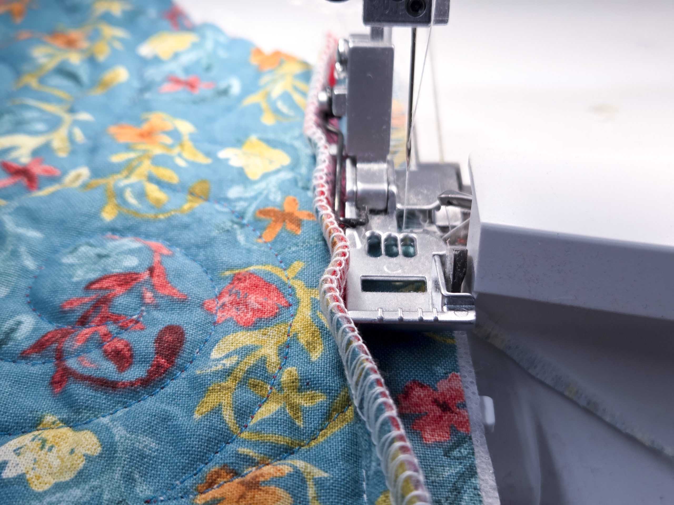 A serger presser foot and blue fabric