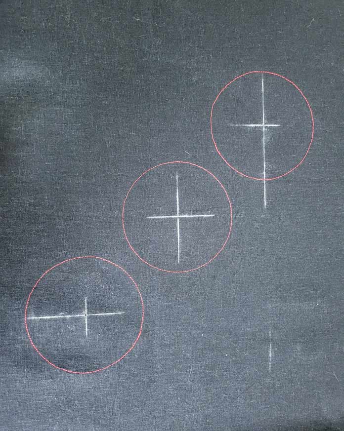 Three red circles with white crosshairs on black fabric