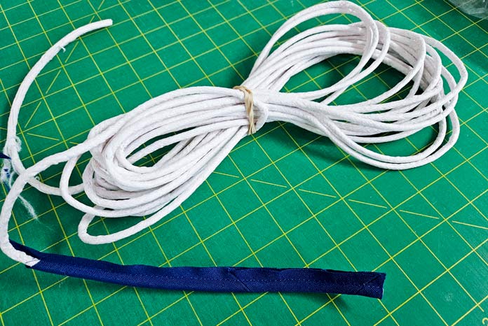 A bundle of white cord with blue piping; Gütermann Nostalgia Box - 50wt Cotton Thread 100m - 48 Shades, Gütermann Nostalgia Box, Flat Felled Foot 9mm, Husqvarna VIKING Opal 690Q, free sewing pattern, outdoor accessories, outdoor cushions, piping, Husqvarna VIKING 8” Bent Trimmer
