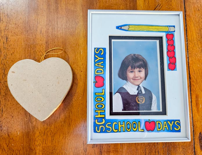 A paper heart and a school picture in a silver frame; Bosal In-R-Form Double-Sided Fusible Foam Stabilizer, Bosal In-R-Form Double Sided Fusible Foam Stabilizer, Bosal In-R-Form Double Sided Fusible Foam Stabilizer, Bosal In-R-Form Unique Sew-In Foam Stabilizer, HeatnBond Tricot Medium Weight Fusible Interfacing, UNIQUE Crafters Choice Fusible Backing, HeatnBond Non-Woven Light Weight Fusible Interfacing, HeatnBond Tricot Medium Weight Fusible Interfacing