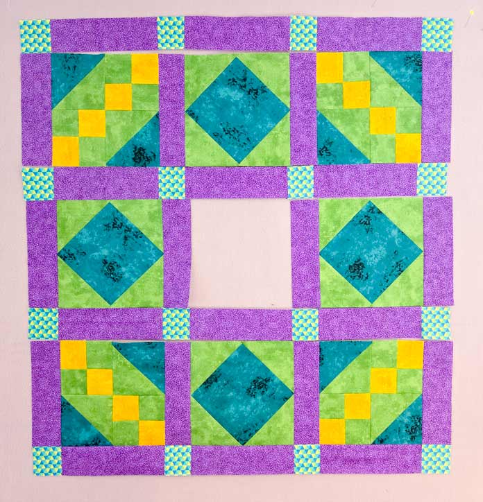 A quilt in purple, green, and yellow