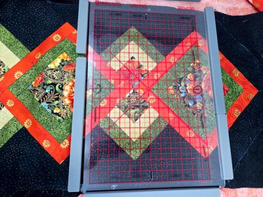 A black and green table runner with a magnetic hoop with red grid lines