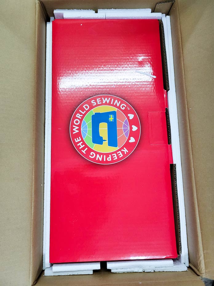 A red box with the Husqvarna VIKING sewing machine logo on it inside a larger box; Husqvarna VIKING ONYX 25