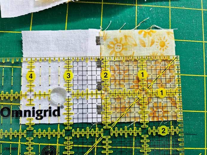 Quilter’s ruler on white and yellow fabric