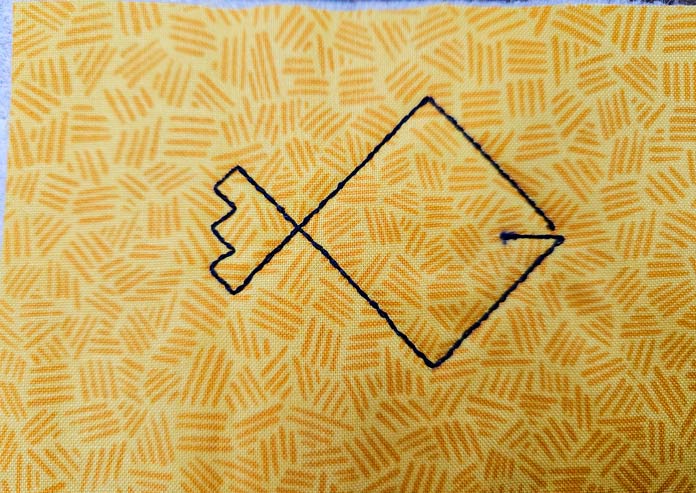 An outline of a fish on yellow fabric