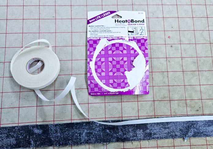 Purple and white packaging and a strip of grey fabric; HeatnBond Lite, quilt binding, fusible web, fabric crafts