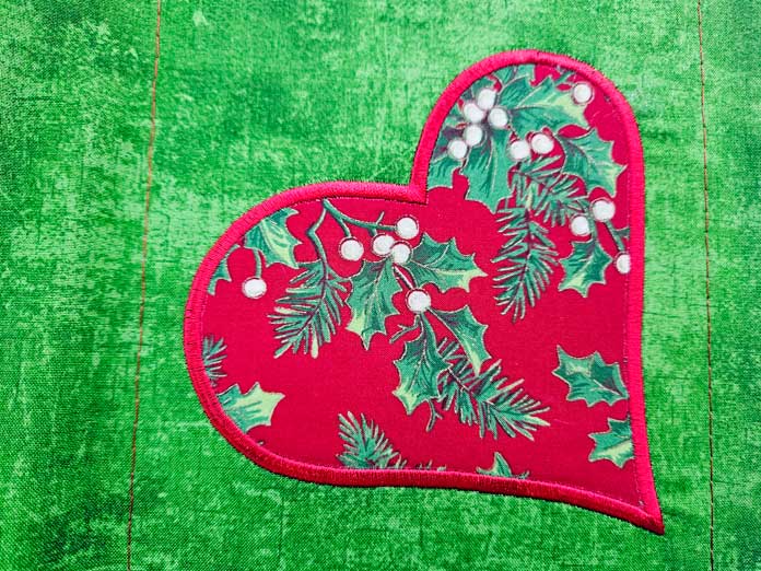 A red heart on green fabric; machine embroidery, quilting, mySewnet, HUSQVARNA VIKING, Designer Epic 3, embroidery software, digital embroidery, quilt block wizard, applique, embroidery design, monogramming