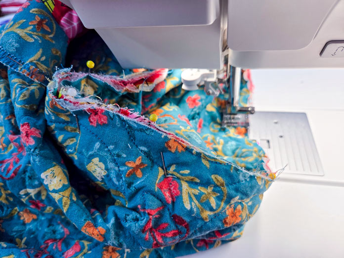 Blue fabric under a metal presser foot