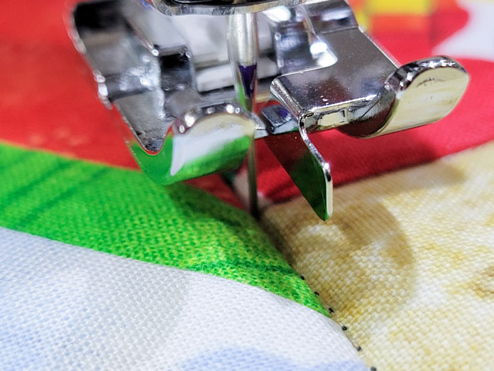 A presser foot in the up position on a quilt; Husqvarna Viking Tribute 150C