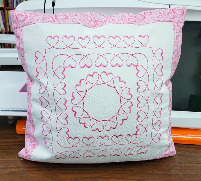 A pink and white cushion cover with hearts; Husqvarna Viking DESIGNER EPIC 2