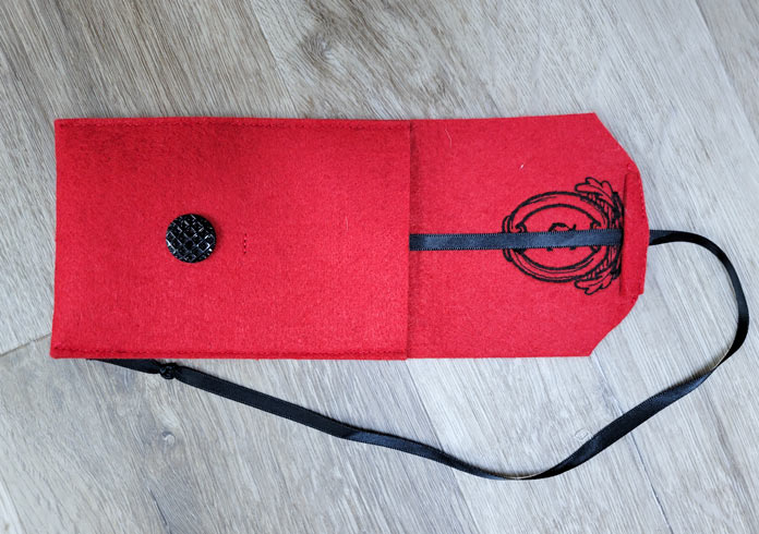 A red phone case with a black ribbon and a black button