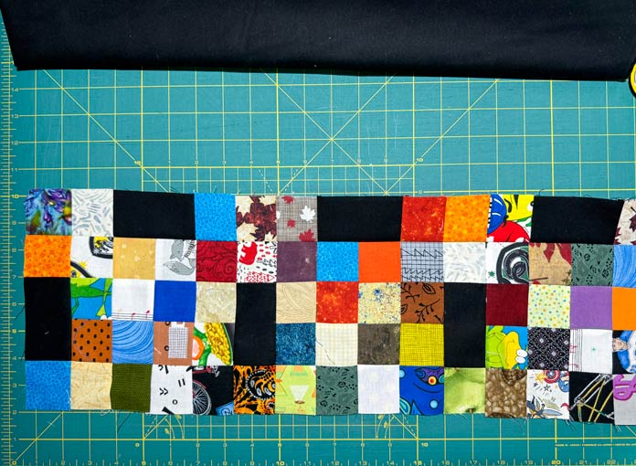 A row with the black rectangles is sewn to a row with the 16 patches.
