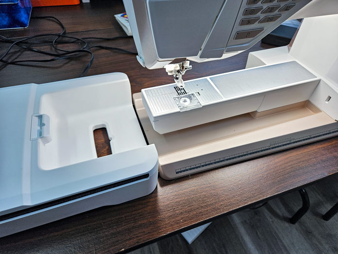 A white embroidery unit is attached to the embroidery machine; Husqvarna VIKING DESIGNER EPIC 3