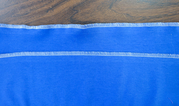 Two lines of white stitching on blue fabric