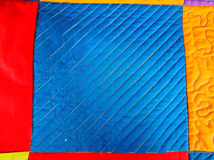 Multi-colored stitching on blue fabric