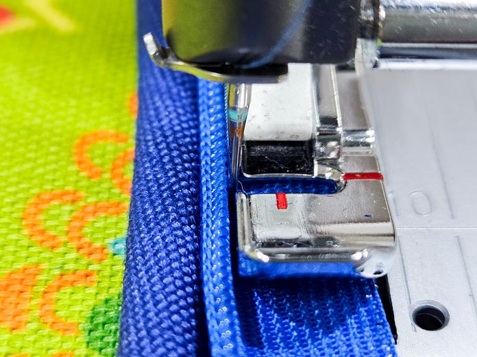 Blue and green fabrics under a metal presser foot; Gütermann Nostalgia Box - 50wt Cotton Thread 100m - 48 Shades, Gütermann Nostalgia Box, Flat Felled Foot 9mm, Husqvarna VIKING Opal 690Q, free sewing pattern, outdoor accessories, outdoor cushions, piping, Husqvarna VIKING 8” Bent Trimmer