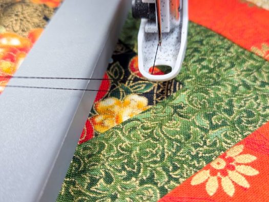 Two black threads on a green fabric